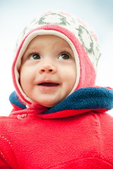 child in hat and in red jacket close-up