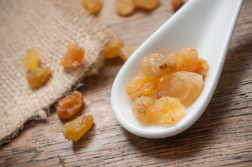 raisins sec et petite cuillère asiatique sur table en bois