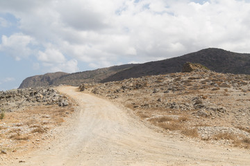 Unpaved dirt road on the hill mountains in Greece