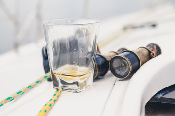 Yacht men set. glass of whiskey and an old pair of binoculars