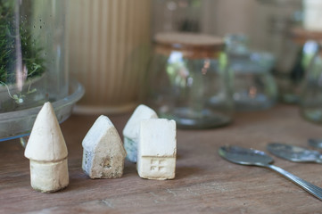 Miniature white clay classic house lay on wooden table, home interior concept.