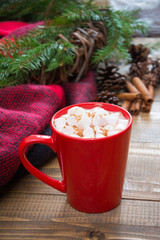Red cup of hot chocolate with marshmallow on windowsill. Weekend concept. Christmas time, morning.