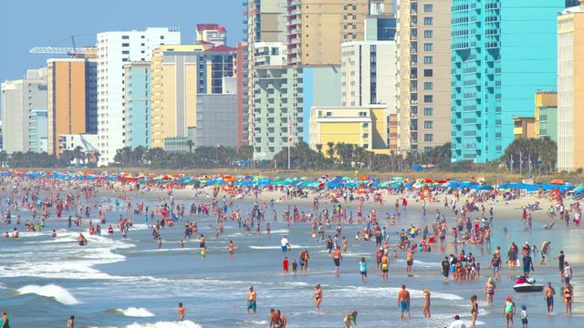 Myrtle Beach SC Summertime Coastal Scene with People Swimming and Sunbathing in Breaking Atlantic East Coast Sea Water at Oceanfront Resort Hotels