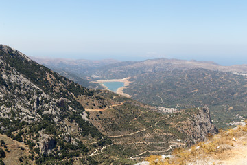 Fototapeta na wymiar Summer mountain path and a lake in valley in Crete, Greece