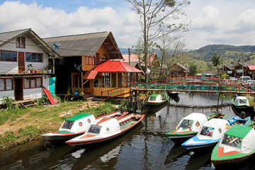 Colorful houses and boats parked on the side of the small river close to the Cocha lake, Colombia, South America