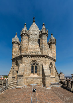 Tower of the Se Cathedral in Evora, Portugal. The spire of the cathedral's tower is surrounded by six turrets, and each turret is a miniature copy of the tower itself.