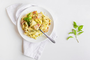 Pasta with avocado and bacon on a white background