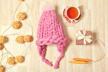 Fototapeta na wymiar Handmade knitwear composition with warm hat of pastel color