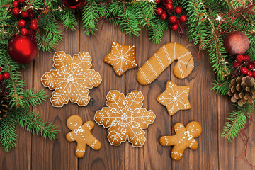 Christmas background with branch of fir tree decorated by gingerbread.