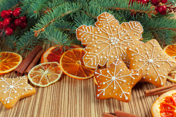 Christmas background with branch of fir tree decorated by gingerbread.
