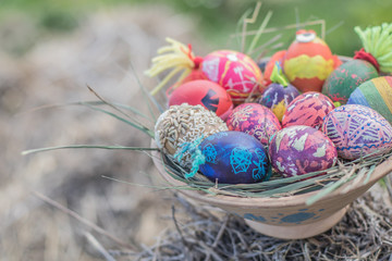 Happy easter modern colorful eggs handmade pottery plate grass chamomile daisies meadow outside