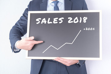 Manager mit Tafel und Verkaufsumsätzen