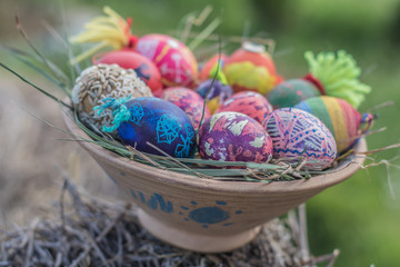 Happy easter modern colorful eggs handmade pottery plate grass chamomile daisies meadow outside