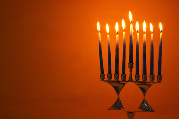 image of jewish holiday Hanukkah background with menorah (traditional candelabra) and candles.