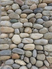 Fototapeta na wymiar Round stones natural wall background in Heraklion Creta ... :-)