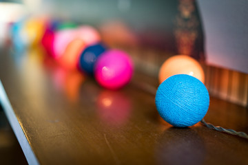Decoration Detail of Coloful Small Spheres with light inside them, on wooden table