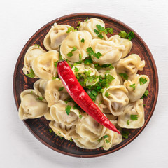 tasty homemade meat dumplings of wholemeal flour or russian pelmeni sprinkled with fresh parsley on...