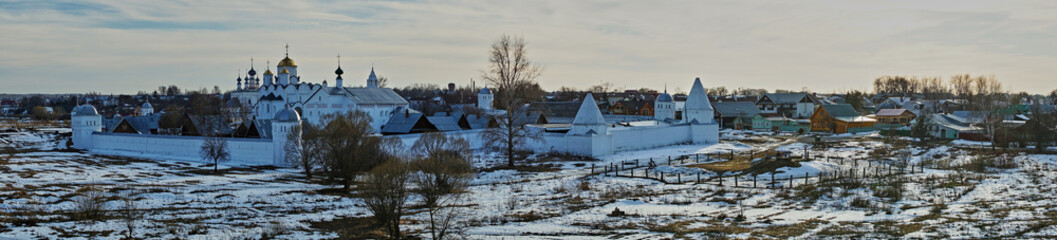 Panorama of the city of Suzdal from a bird's eye view/Panorama of Suzdal from the air. Houses, temples, streets, trees are visible. In the yards lies snow. Suzdal. Golden Ring of Russia