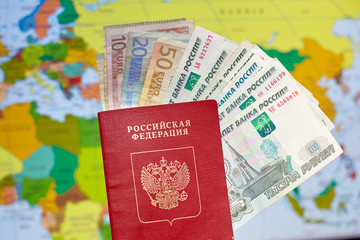Russian passport with euro banknotes and rubles on the background of the world map