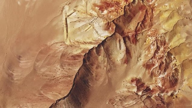 Orange-brown rock, similar to the surface of the planet Mars. Kyzyl-Chin, Mountain Altai: mercury in the rock gives a red tint. Taken from a bird's eye view. Amazing places of nature.