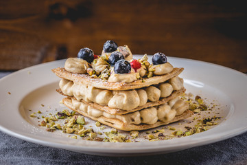 Homemade sugar free mille feuille with blueberries and pistachio