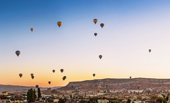 Many Hot air balloons flying over Goreme town in Cappadocia, panoramic view