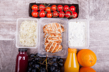Lunch packed in different boxes. Fresh and healthy eating on wooden background