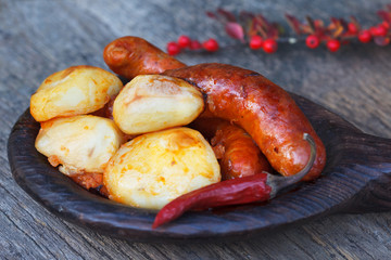Rustic tray with roasted potatoes and sausages