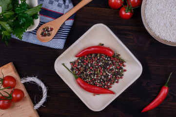 red peppers and vegetables on the dark wood table top view