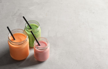 Jars with yummy smoothie on table
