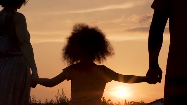 Happy young family watching sunset feeling love and support of each other
