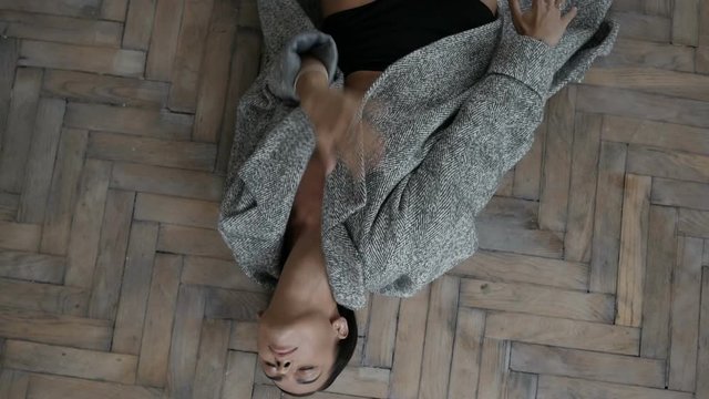 Woman in coat lying on floor