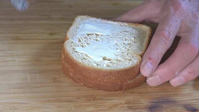 Buttering bread on a cutting board, 4k