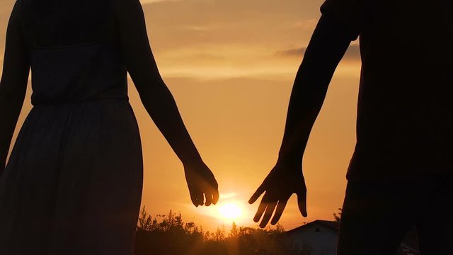 Couple separating their hands at sunset, love story ending, family break-up