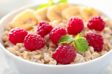 Tasty oatmeal with fruits in bowl, close up