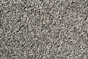 Black and white small round grains  covering a vertical wall surface