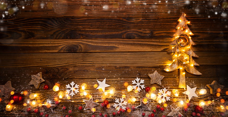 Christmas background with wooden decorations, tree and spot lights.