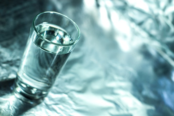 Glass of water on silver abstract background