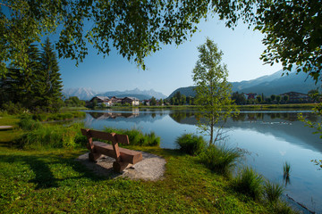 Pond in Alps with clear still water surface and swimming ducks. Seefeld, Austria