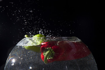 Fototapeta na wymiar peppers falling into water
