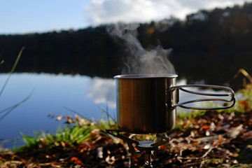 cooking cup during outdoor kitchen on a silent lake