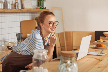 Positive joyful woman looking at the laptop screen