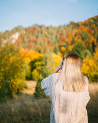 girl taking shoots of nature on autumn day 