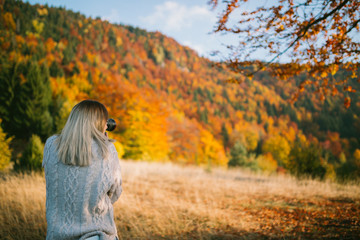 girl taking shoots of nature on autumn day 