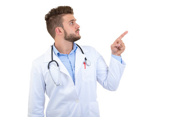 Portrait of a Young smiling male doctor pointing finger away isolated on a white background
