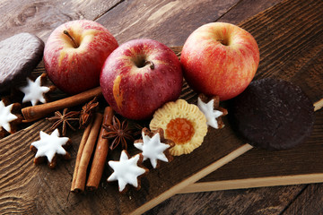 Naklejka na ściany i meble christmas cookies, apples, gingerbread and spice on brown background