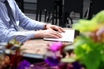 Business man working and analyzing financial figures on a graphs on a laptop outside