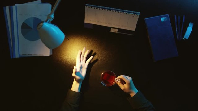 A man is sitting at an office desk and using a phone.