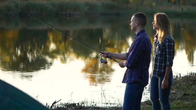 Happy young couple at lake pike fishing