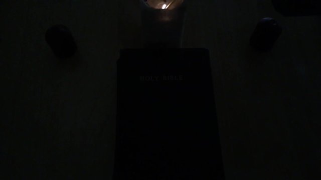 Candles are lit around holy bible and match is extinguished shortly afterwards.